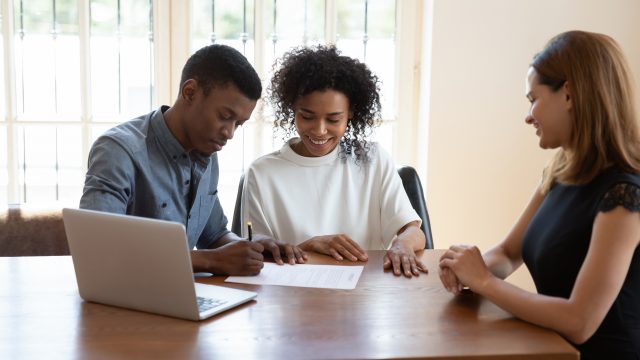 couple with laptop signing papers