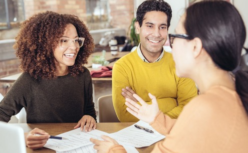 couple talking with agent reviewing documents
