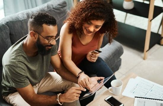 couple on couch looking at laptop