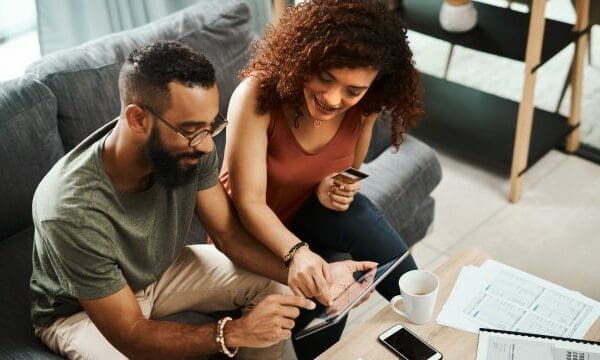 couple on couch looking at laptop