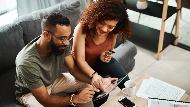 couple on couch looking at laptop